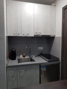 a kitchen with white cabinets and a sink at D&B Apartment 3 in Paralia Katerinis
