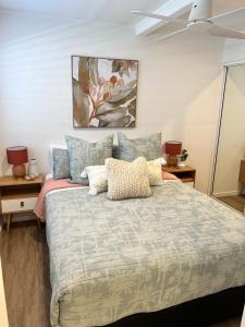 a bedroom with a large bed with pillows at Comfortable Beach Home Scarborough in Scarborough