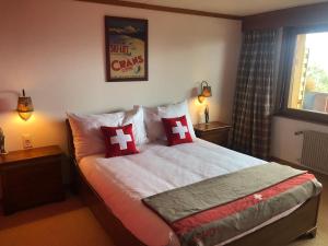 a bedroom with a bed with red and white pillows at Colorado Riders Chalet in Crans-Montana