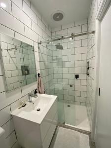 a white bathroom with a sink and a shower at Beautiful Guesthouse in Monbulk in Monbulk