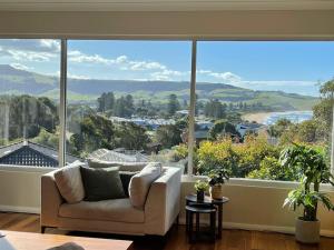 a living room with a couch and a large window at Seaview at Gerringong - 4pm check out if available in Gerringong
