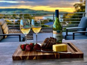a table with two glasses of wine and cheese and strawberries at Seaview at Gerringong - 4pm check out if available in Gerringong