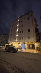 شقة الشوقية في مكة المكرمة: مبنى كبير فيه سيارة متوقفة أمامه