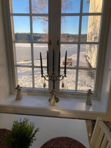 a window with three candles on a table in a room at Entire Town House on Ground floor front of Lake in Märsta