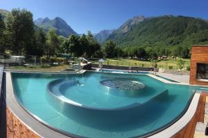 una grande piscina con montagne sullo sfondo di La ruelle des 2 vallées ad Arreau
