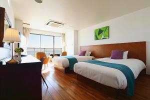a hotel room with two beds and a large window at Sayan Terrace Hotel & Resort in Onjuku