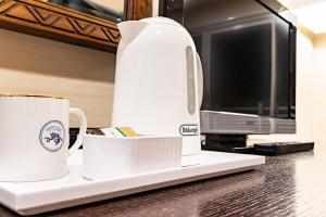a coffee maker and two cups on a counter at Sayan Terrace Hotel & Resort in Onjuku