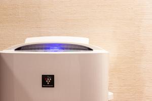 a white toaster with a blue light on it at Sayan Terrace Hotel & Resort in Onjuku +1 photo