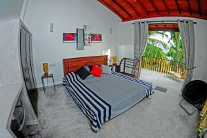 um quarto com uma cama grande e uma varanda em THE SANCTUARY- Tangalle em Tangalle