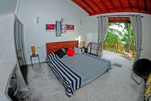a bedroom with a large bed and a balcony at THE SANCTUARY- Tangalle in Tangalle