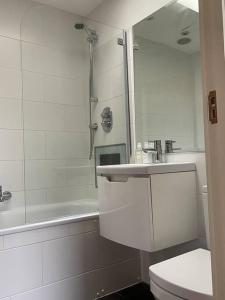 a bathroom with a sink and a toilet and a tub at Amazing apartment central London near tube station in London