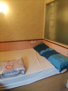 a small bed in a room with a window at 嘉湖旅館 in Hong Kong