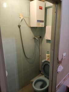 a small bathroom with a toilet with a shower at 嘉湖旅館 in Hong Kong