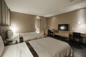 a hotel room with two beds and a flat screen tv at Motel Stars in Taichung