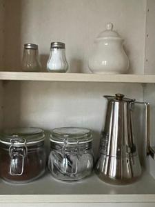 a shelf filled with glass jars and a tea kettle at Apartament Lubelski Zamkowy in Lublin