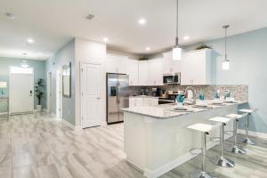 a kitchen with white cabinets and a large island with bar stools at Champions Gate Resort, Game Room, Theater, Miles From Disney! in Davenport