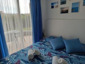 ein Schlafzimmer mit einem Bett mit blauen Kissen und einem Fenster in der Unterkunft Casetta alla Spiaggia Ventimiglia in Ventimiglia