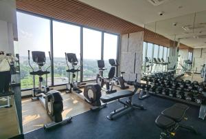 a gym with lots of exercise equipment and large windows at Modern style room with sky pool 古城边天际泳池公寓 in Chiang Mai