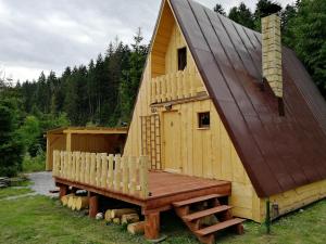 ein großes Holzhaus mit einer Bank davor in der Unterkunft Chata Zuzka pod Babou horou in Oravská Polhora