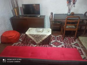 a living room with a red couch and a table at ForestRock Studio FOR SALE TOO in Sparti