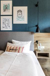 ein Schlafzimmer mit einem weißen Bett und einigen Bildern an der Wand in der Unterkunft Hotel Wehrburg in Cuxhaven