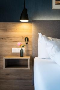 ein Schlafzimmer mit einem Bett und einem Tisch mit einer Blume darauf in der Unterkunft Hotel Wehrburg in Cuxhaven
