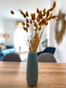 唐貝尼托的住宿－Amplio y luminoso apartamento en el centro，花朵坐在桌子上的蓝色花瓶