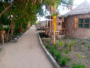 a walkway next to a house with a building at Mwanza lake view FARM Eco LODGE in Sengerema
