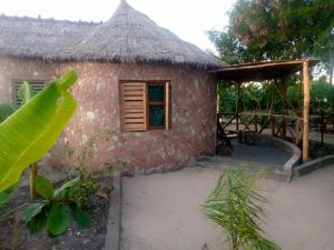 a small brick house with a thatch roof at Mwanza lake view FARM Eco LODGE in Sengerema