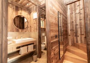 a wooden bathroom with a sink and a mirror at Chalet Tschogerhof Tiers am Rosengarten Dolomiten in Tires