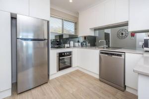 a kitchen with a stainless steel refrigerator at Sparkling water views over Shoal Bay beach in Shoal Bay
