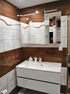 La salle de bains est pourvue d'un lavabo blanc et d'un miroir. dans l'établissement Apartmán West, à Poprad