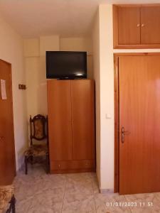a room with a tv on top of a wooden cabinet at ΡΑΧΗ in Kerasea