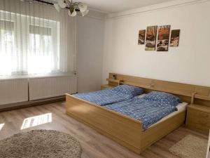 1 dormitorio con 1 cama en una habitación con ventana en Anikó nyaralóház, en Badacsonytomaj