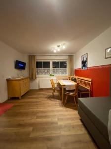 sala de estar con mesa, sillas y TV en Apartment Emma, en Mayrhofen