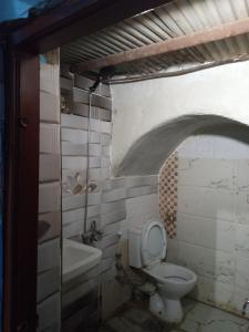 a bathroom with a toilet and a sink and a tub at HORUS Nubian Guest House in Aswan