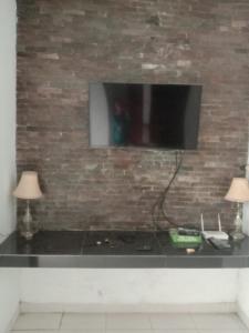 a black counter with a television on a brick wall at Dee homes singaraja in Singaraja