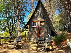 a small cabin with two chairs in front of it at Agriturismo Pereti in Roccatederighi