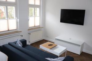 a living room with a blue couch and a tv at Haus Fischer in Norderney