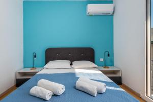 a bed with two pillows on it with a blue wall at Rhodes Central Apartment in Rhodes Town +7 photos