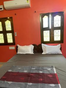 1 dormitorio con 1 cama con paredes y ventanas de color rojo en RIVER VIEW HOME STAY SERVICE APARTMENT en Madurai