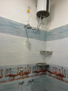 un baño con un montón de flamencos pintados en la pared en RIVER VIEW HOME STAY SERVICE APARTMENT en Madurai