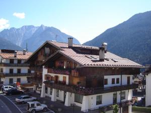 a building in a town with mountains in the background at Appartamento "Vista Lago" in Auronzo di Cadore
