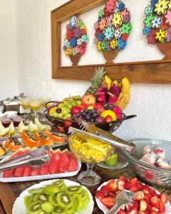un buffet de fruits et légumes sur une table dans l'établissement Pouso das Flores -350m Maria Fumaça, à Tiradentes