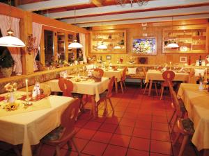 a restaurant with white tables and chairs in it at Hotel Diana in Pörtschach am Wörthersee