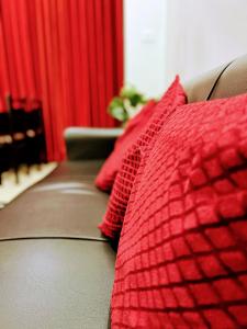 czerwone łóżko z 2 czerwonymi poduszkami w obiekcie Mesmerizing comfy condo with world class amenities w mieście Manipala