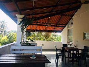 a dining room with tables and chairs and a large window at Eden Blue Hikkaduwa in Hikkaduwa