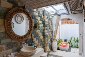 baño con espejo grande y lavabo en Amaya Sebatu Villa, en Ubud