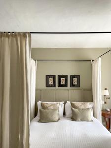 a bedroom with a large bed with white sheets and pillows at Corte Gondina Boutique Hotel in La Morra