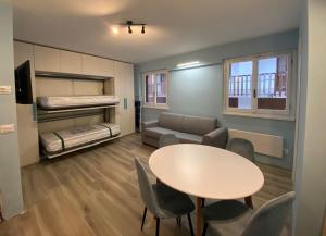 Zimmer mit einem Tisch, einem Sofa und einem Bett in der Unterkunft Sendy Home Roccaraso 2 in Roccaraso